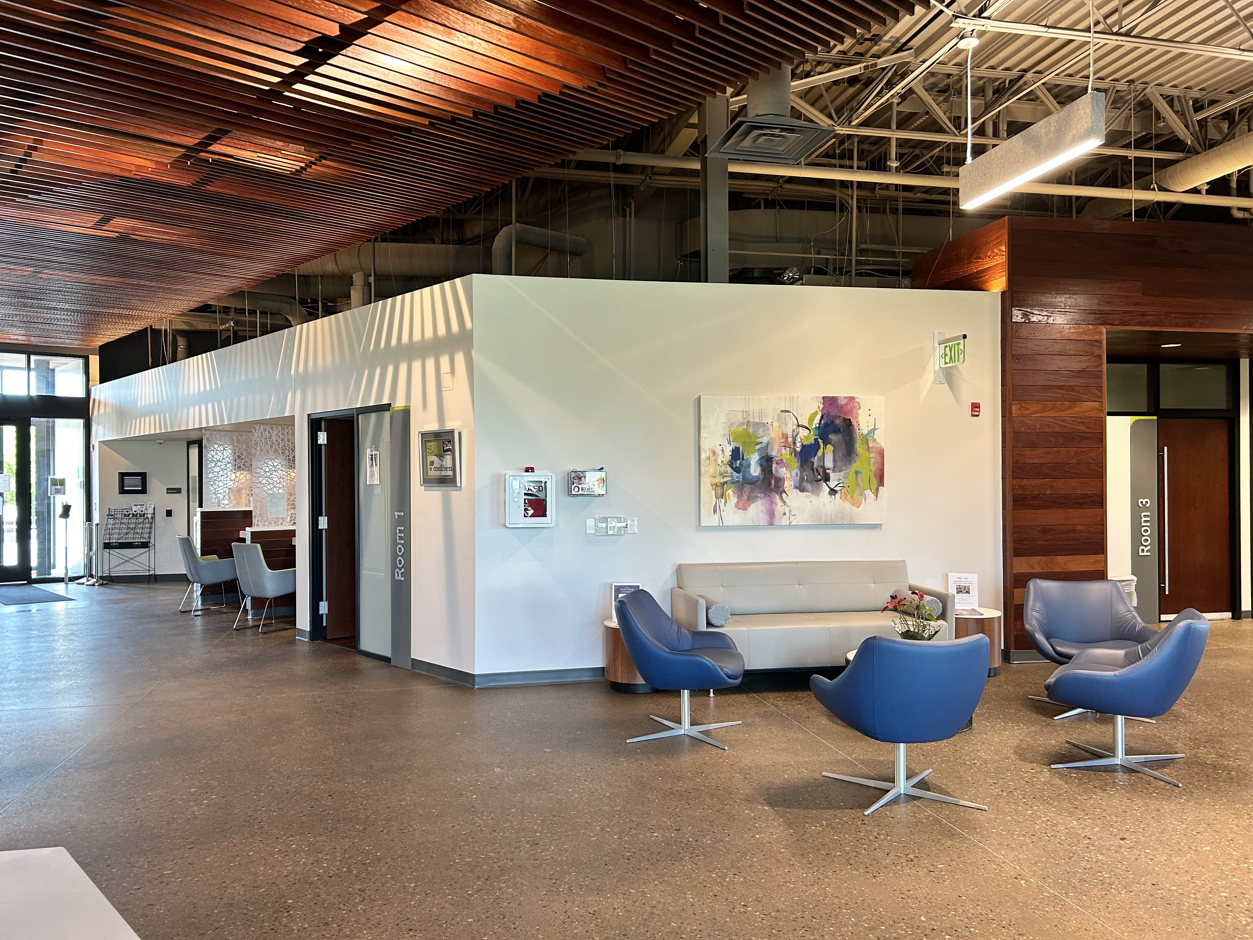 OneFifteen clinic concourse with warm wood finishes and inviting furniture