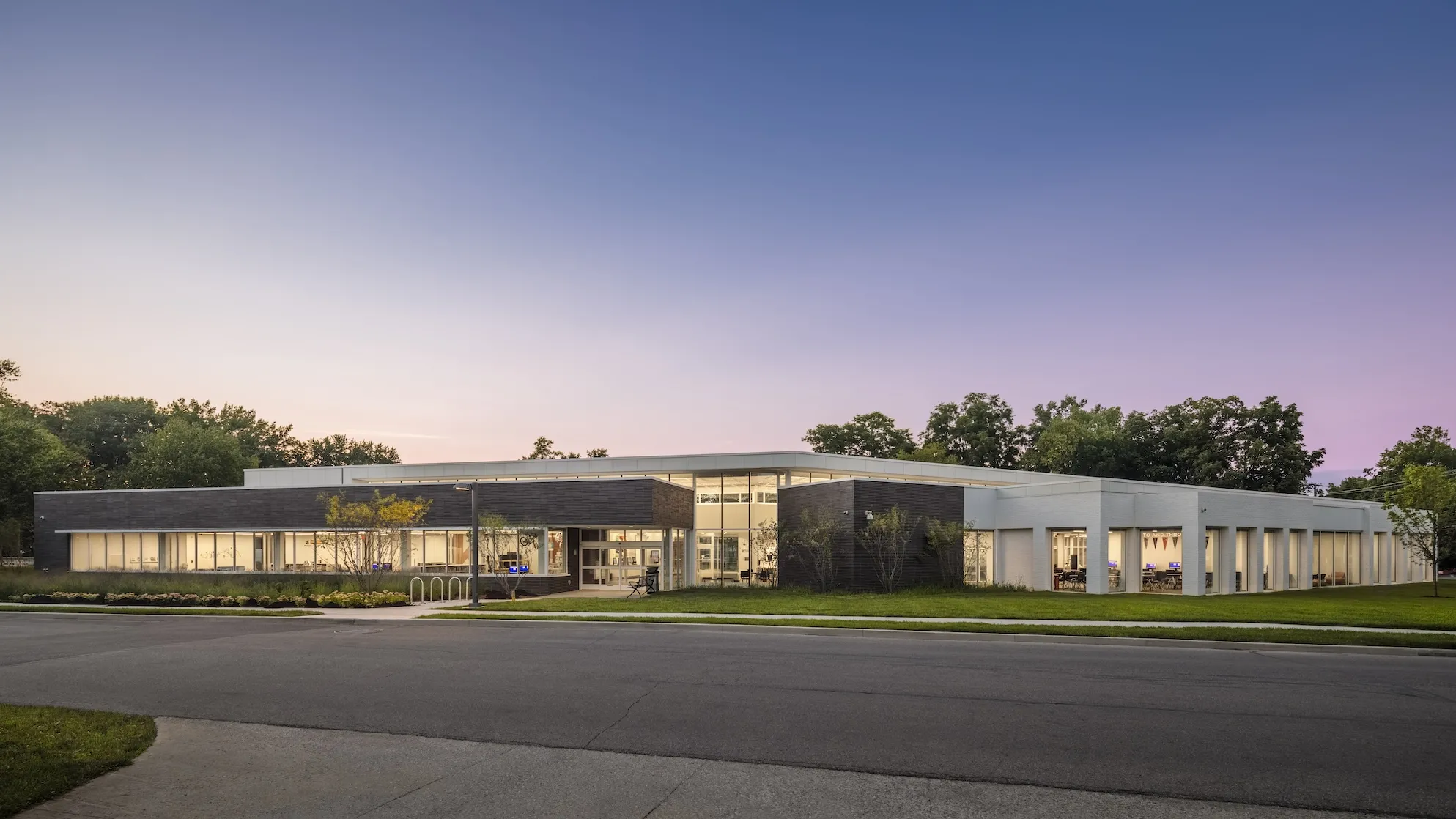 Exterior dusk of the Northern Lights Columbus Library, a modern grey and white floor to ceiling windowed building