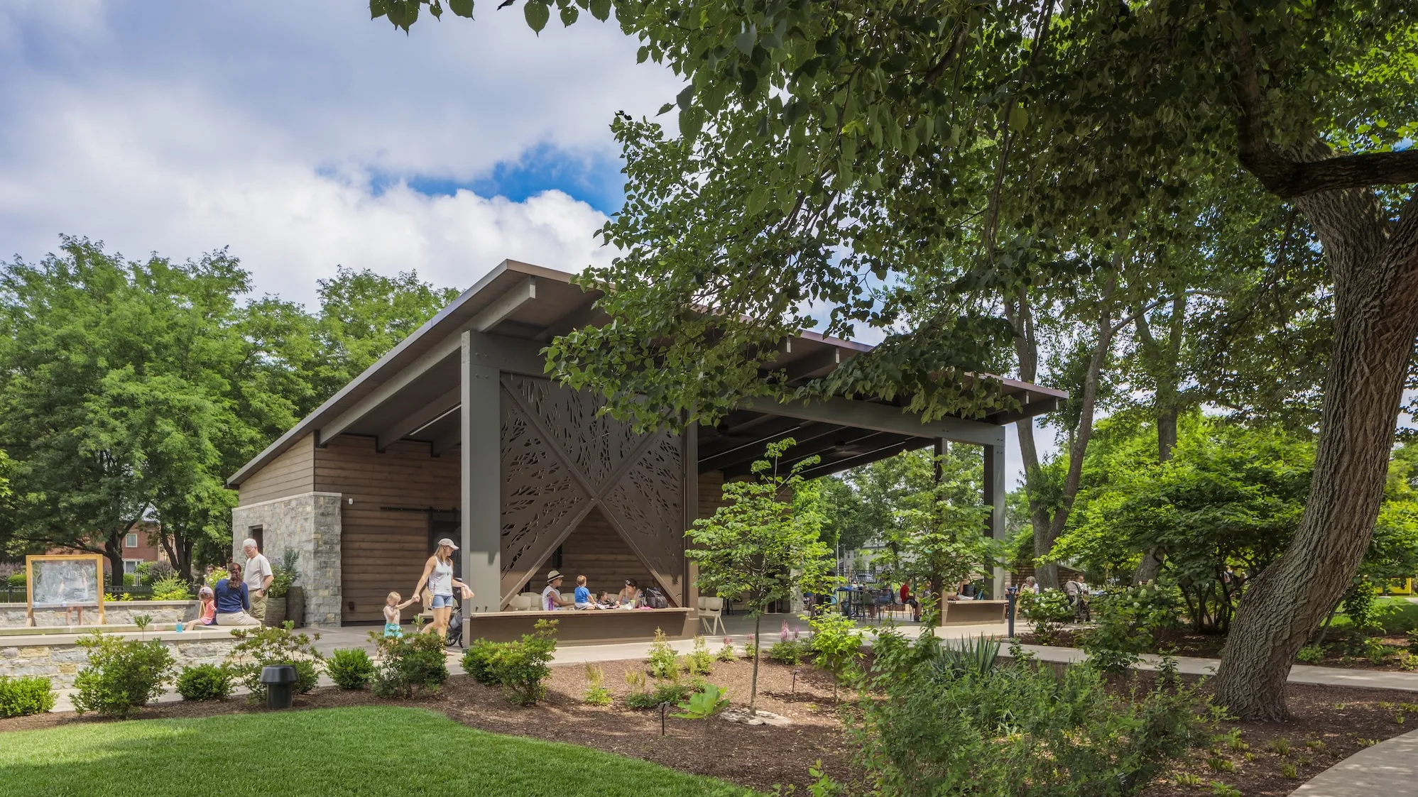 Outside daytime of a large gazebo surrounded by variety of plants and trees