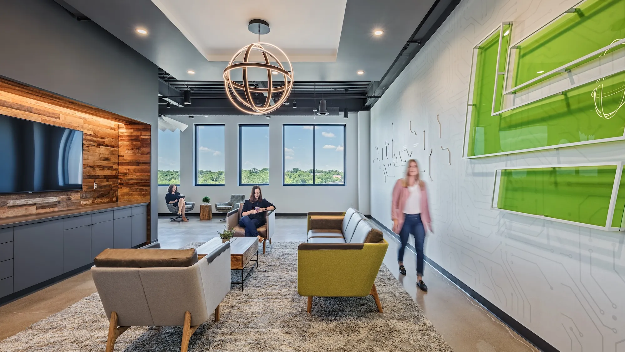 Interior of a lobby or lounge space with modern couches and a wall featuring a motherboard tech design