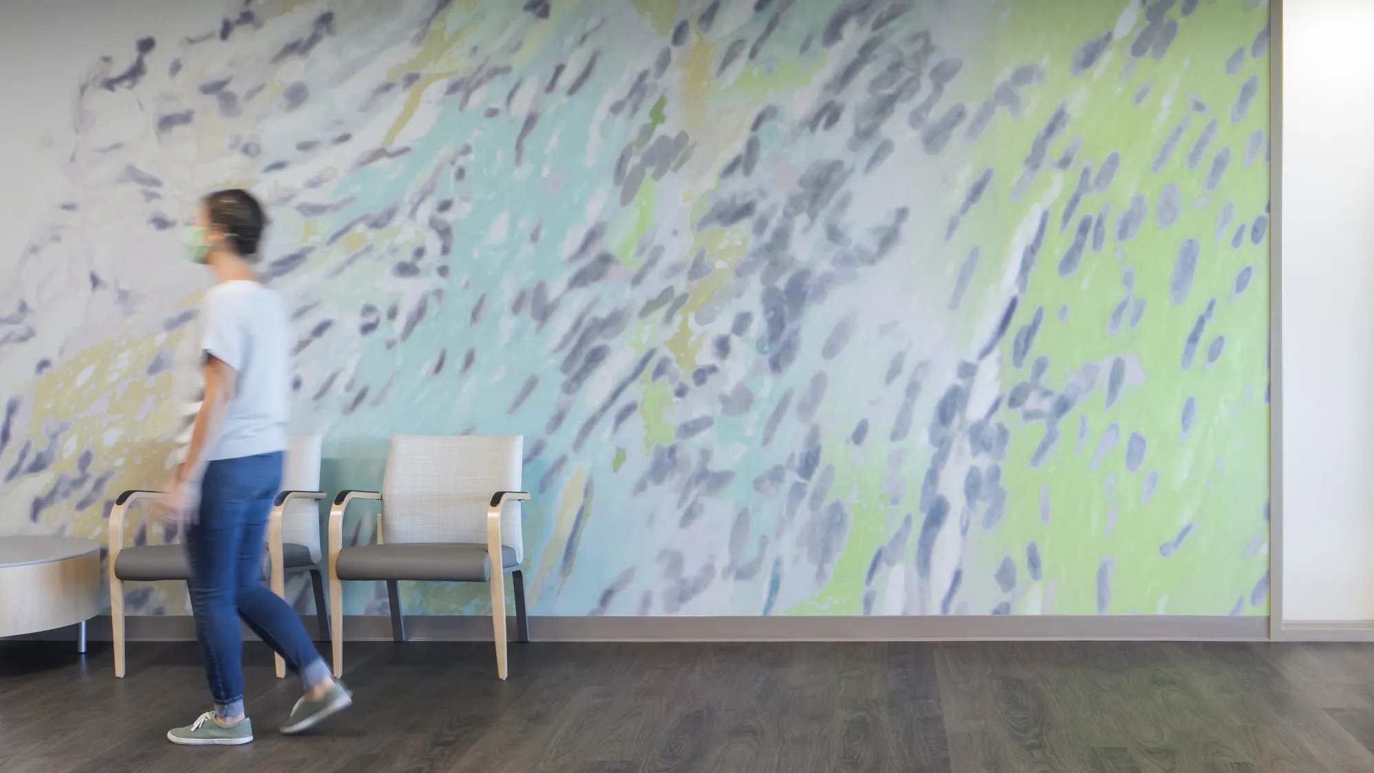 woman walks past mural