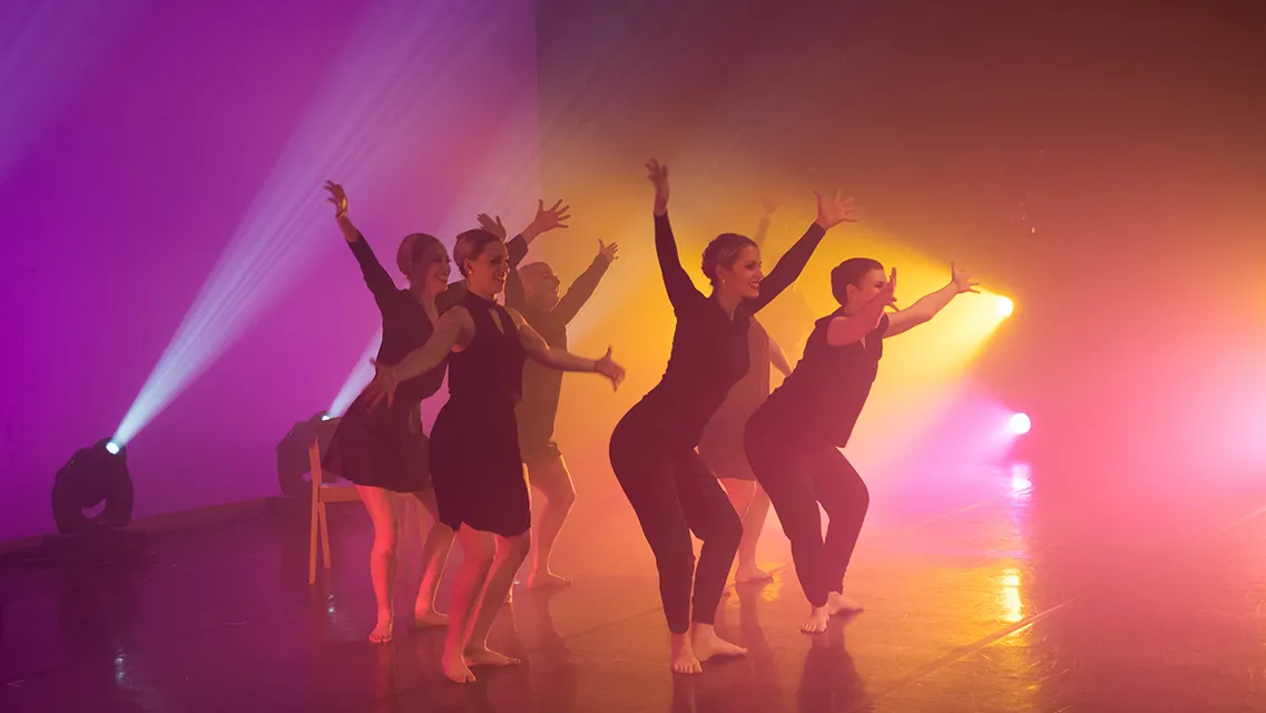 dancers on stage with colored lighting