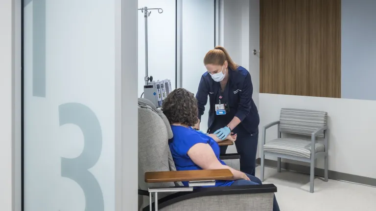 Interior of a room with a nurse and patient, beginning to draw blood