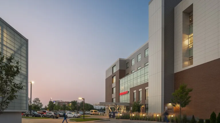 Exterior dusk of an inpatient hospital entrance and parking lot