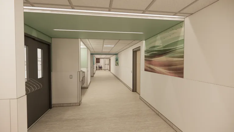 Hallway of a hospital with white walls and accents of light green