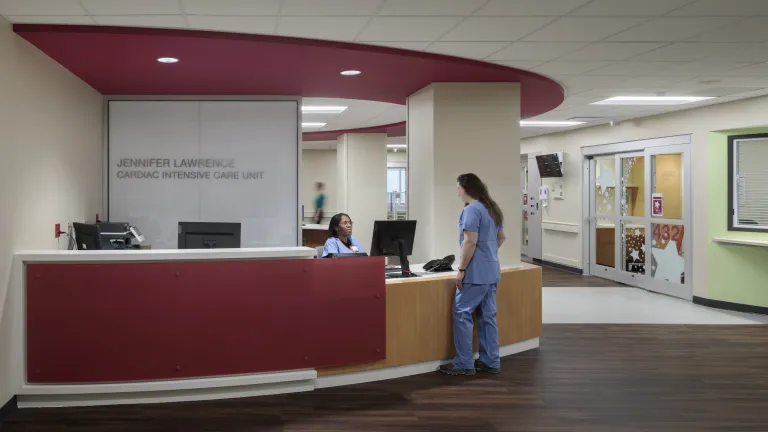 Front desk space of the Jennifer Lawrence Cardiac Intensive Care Unit featuring a check in desk with red accents