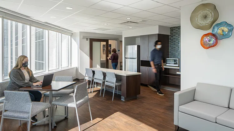 Interior day of a family style waiting room with tables and kitchenette