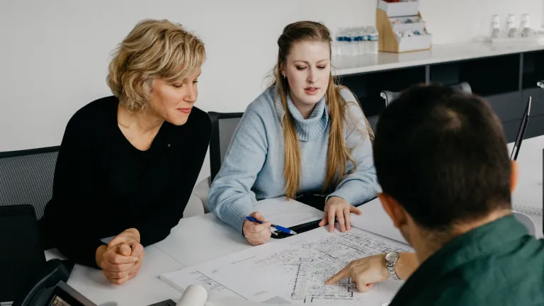 Architects around a table collaborating on plans.