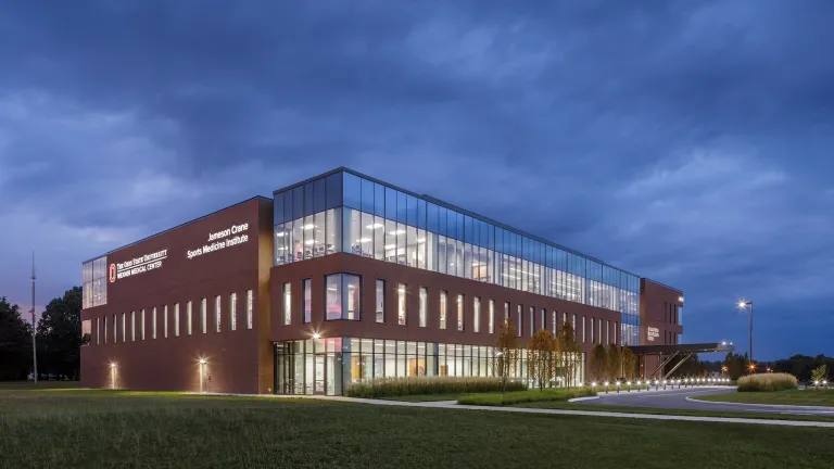 Exterior of Jameson Crane Sports Medicine Institute at night, featuring brick and large windows