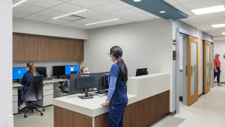 Interior of a nurses or staff station with two women interacting at a desk