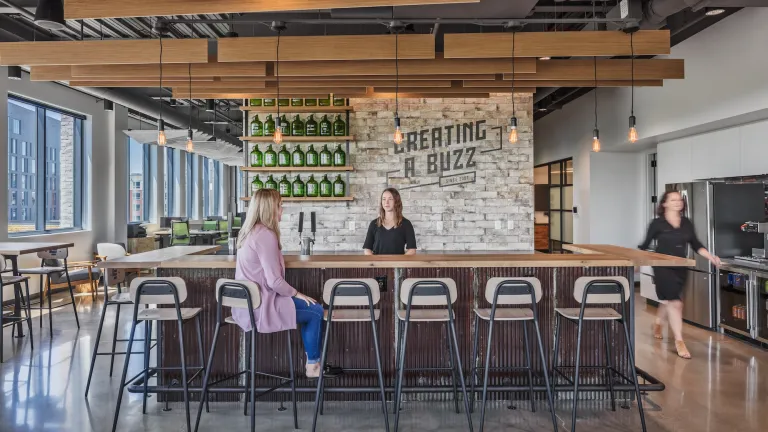 Center bar space called Creating a Buzz with a bartender behind the counter and a woman sitting in front