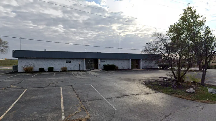 View of a low profile building across a parking lot.