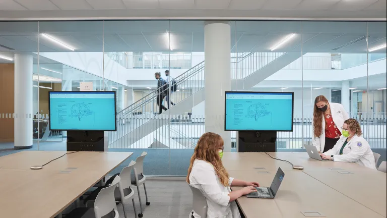 Students in a classroom collaborating and working.