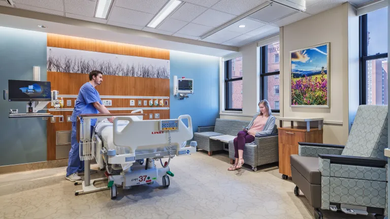 nurse prepares bed in inpatient room