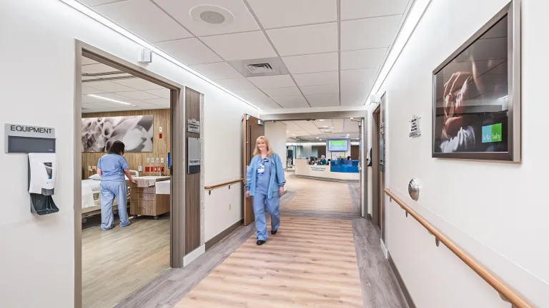 nurse walks down hospital corridor