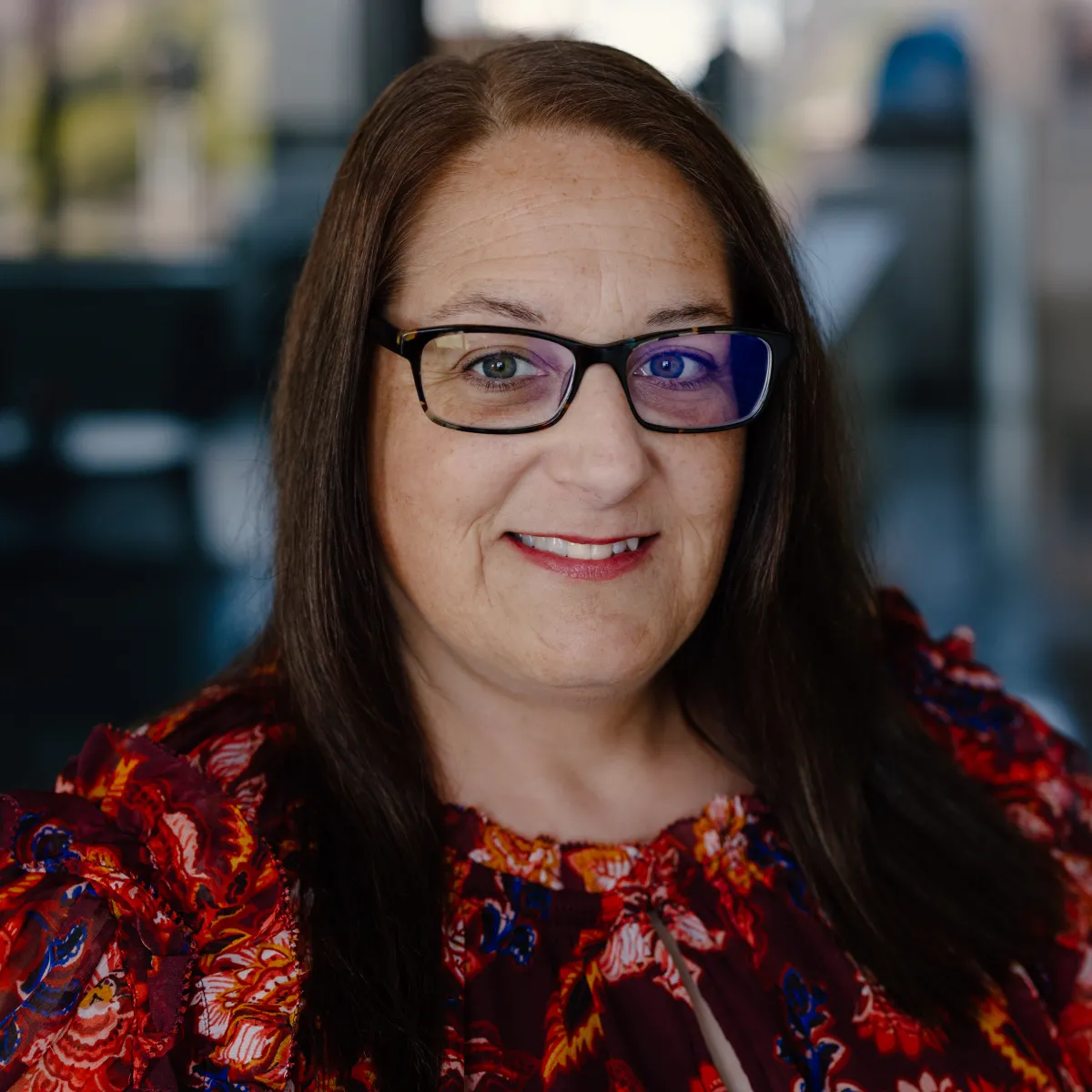 Cindy Richmond smiling, wearing a floral red blouse
