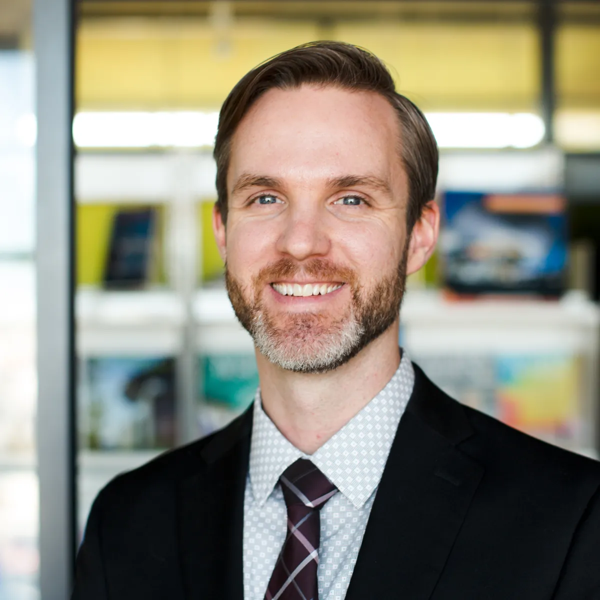 Jeff McCambridge smiling, wearing a black blazer and tie