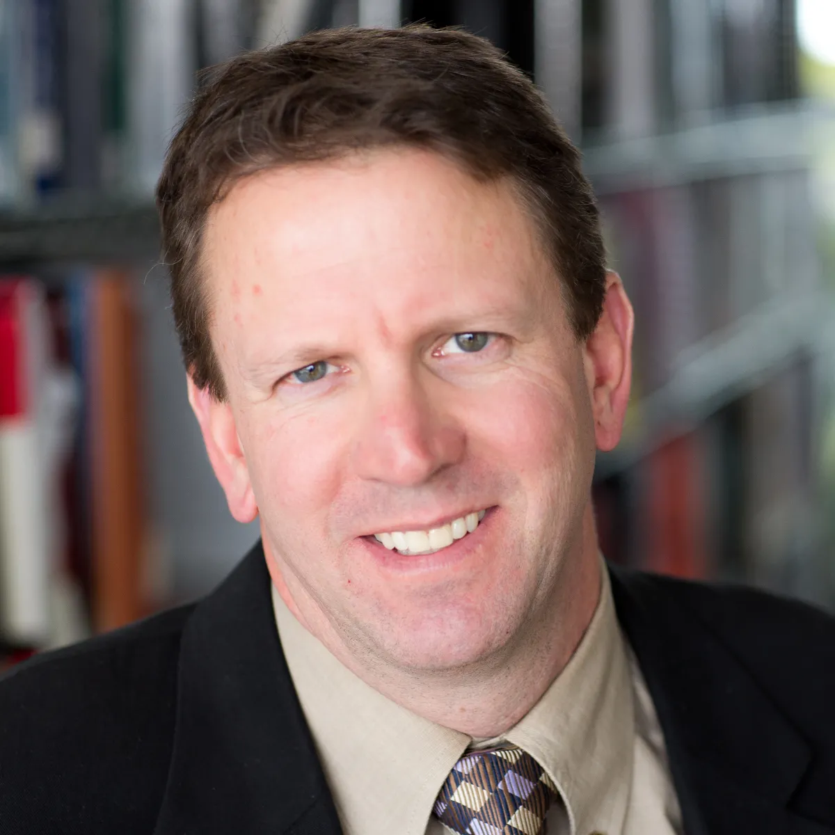 Jon Sofranec smiling, wearing a black blazer