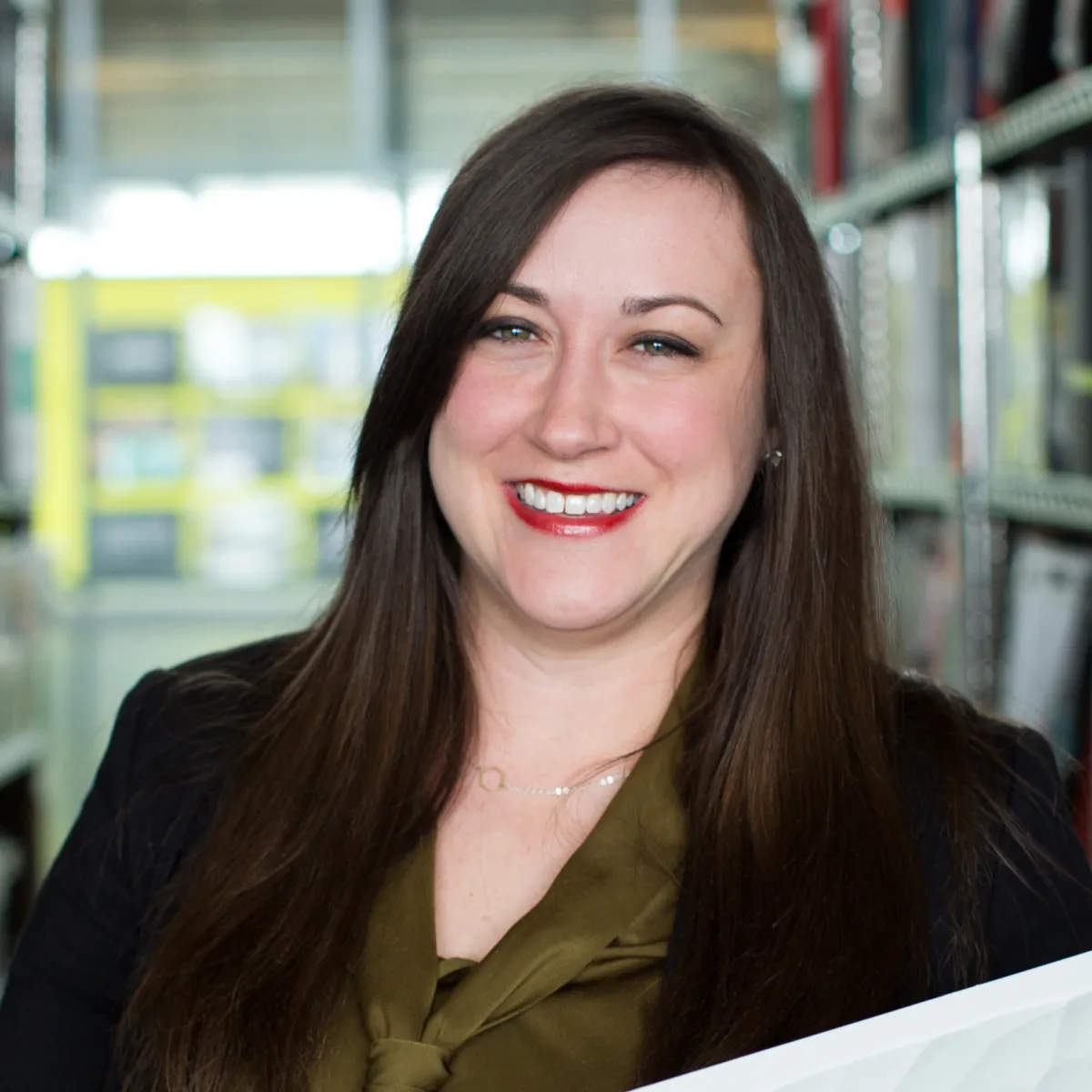 Riley Zollars smiling, wearing a black blazer and dark green blouse