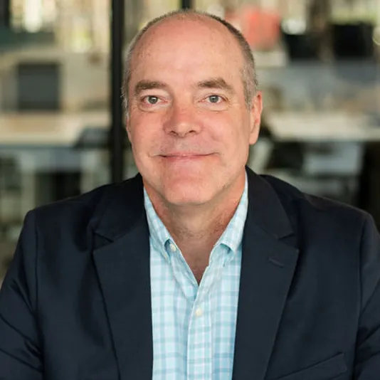 Tom Chidlow, smiling while wearing a navy blazer and blue shirt