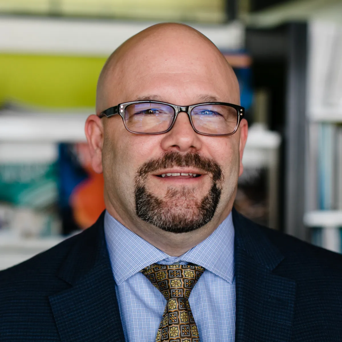 Tom Stanko smiling, wearing a navy blazer and blue shirt