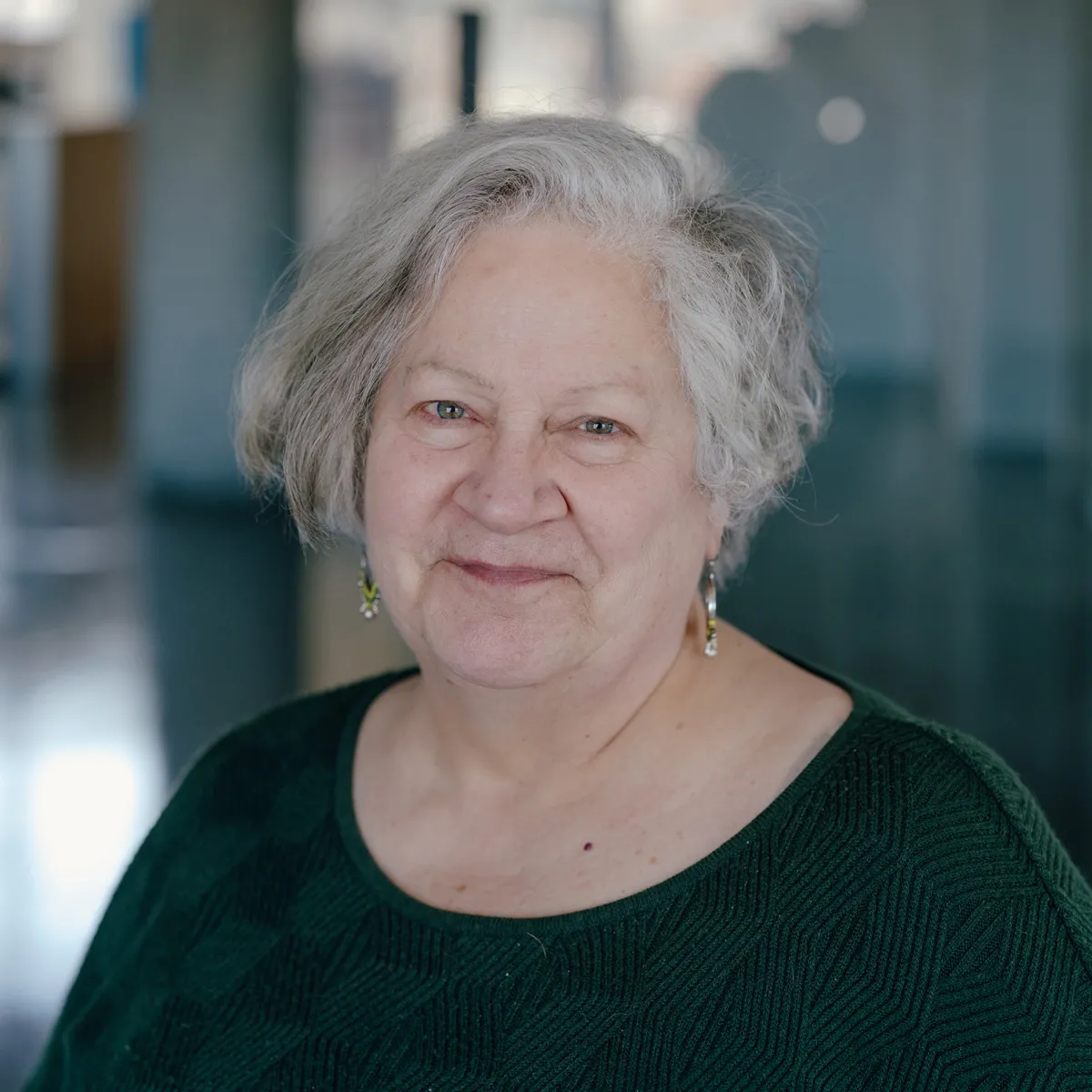 woman wearing dark green sweater in office