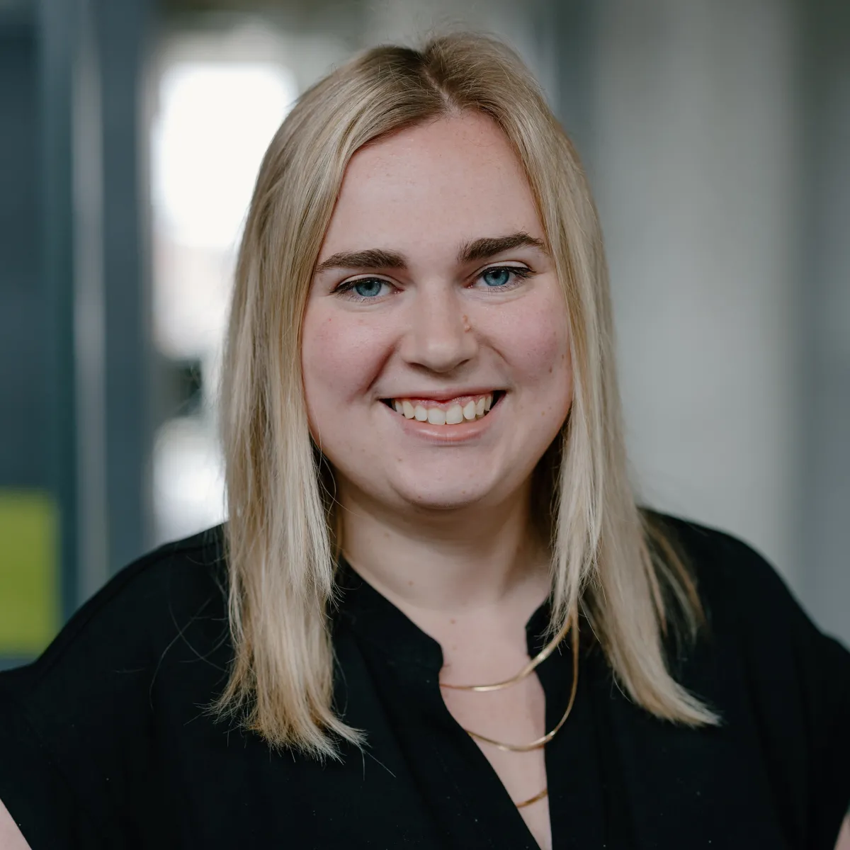 woman with straight blonde hair and black blouse