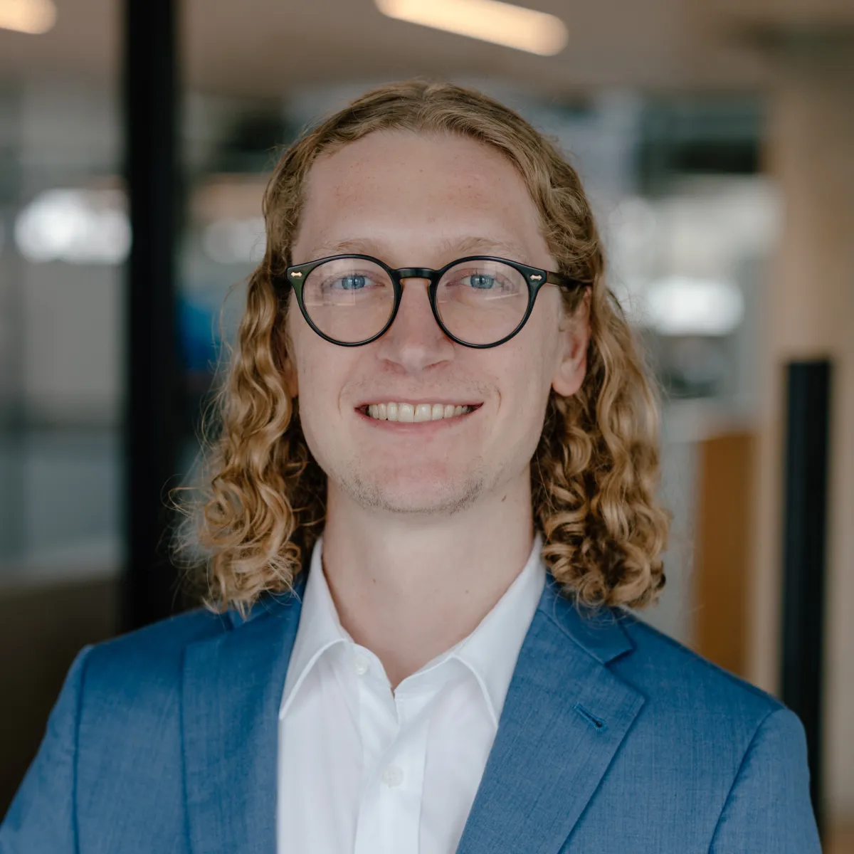 man with glasses and blue jacket