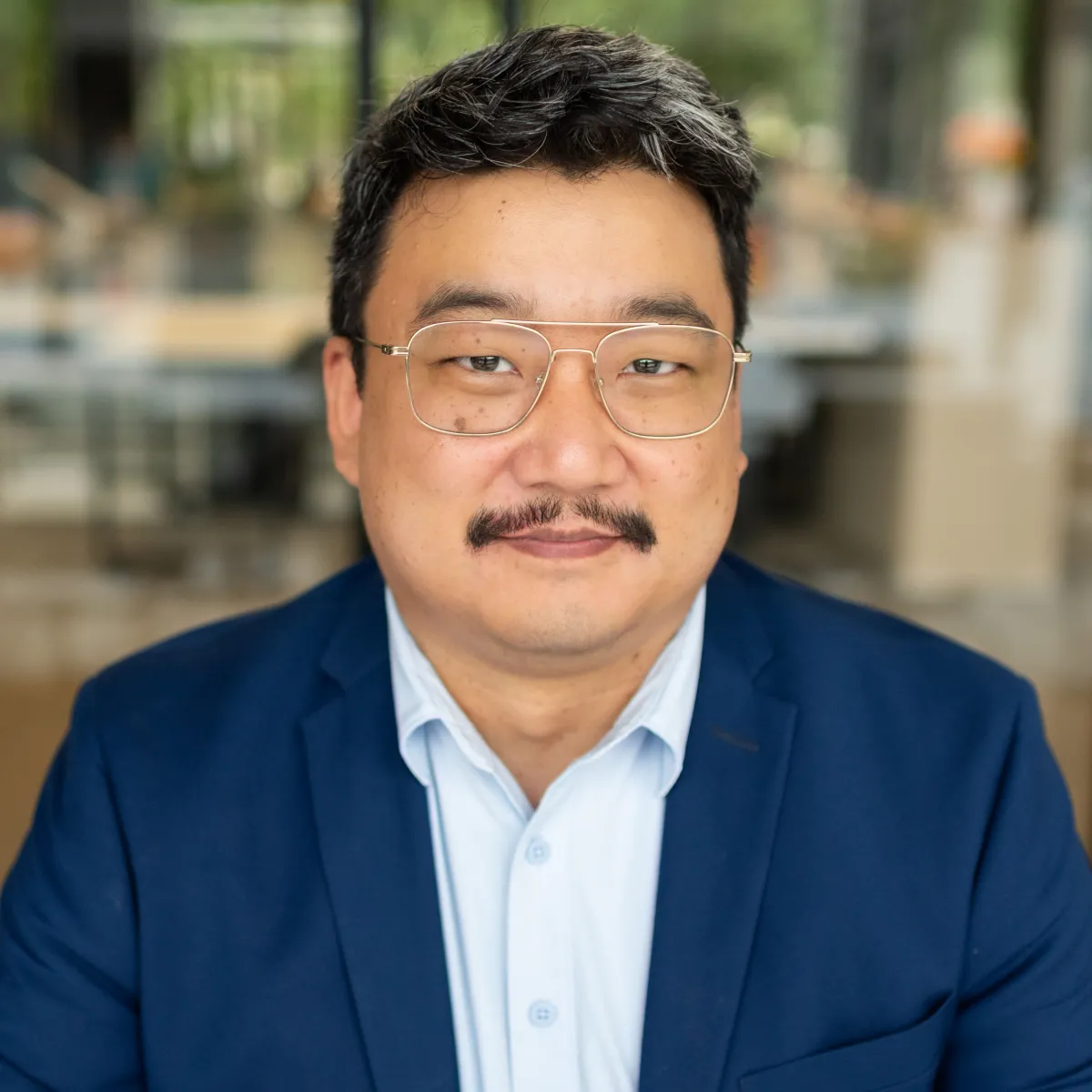 man with wireframe glasses and mustache