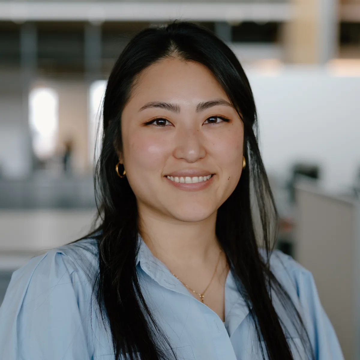 woman with straight dark hair wearing a light blue blouse