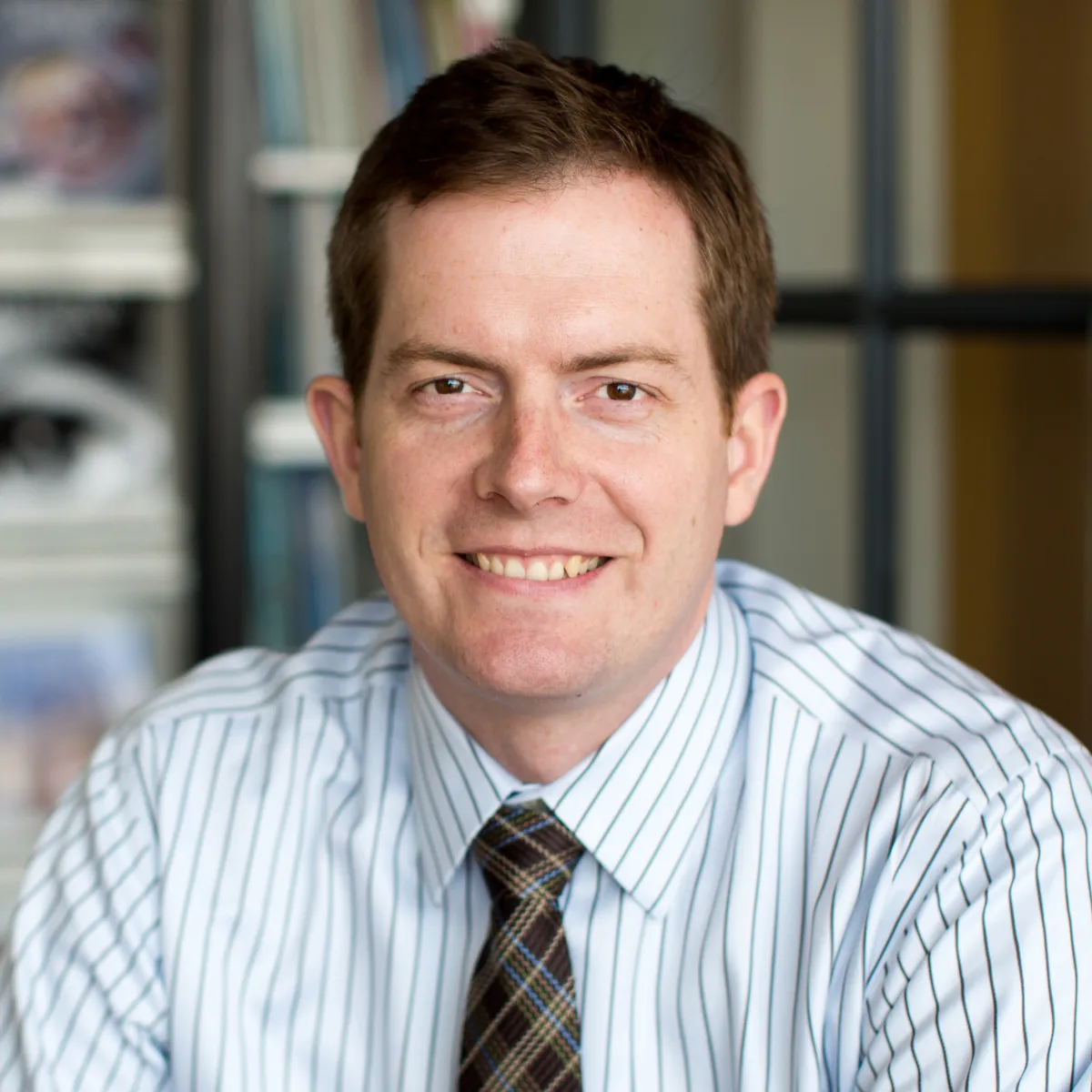 man in striped blue shirt and plaid tie