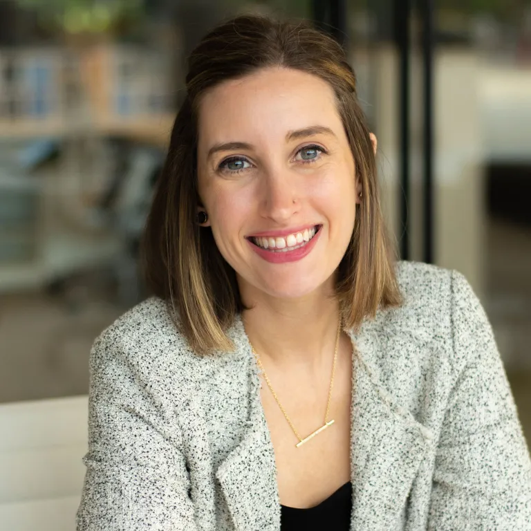 Nicole DeFazio smiling, wearing a gray blazer and black blouse