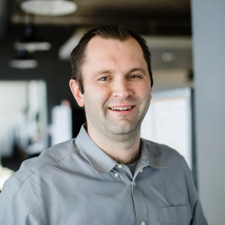 headshot of man with grey shirt