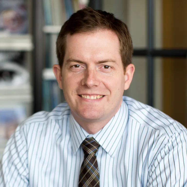 man in striped blue shirt and plaid tie