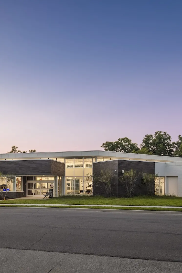 Exterior dusk of the Northern Lights Columbus Library, a modern grey and white floor to ceiling windowed building