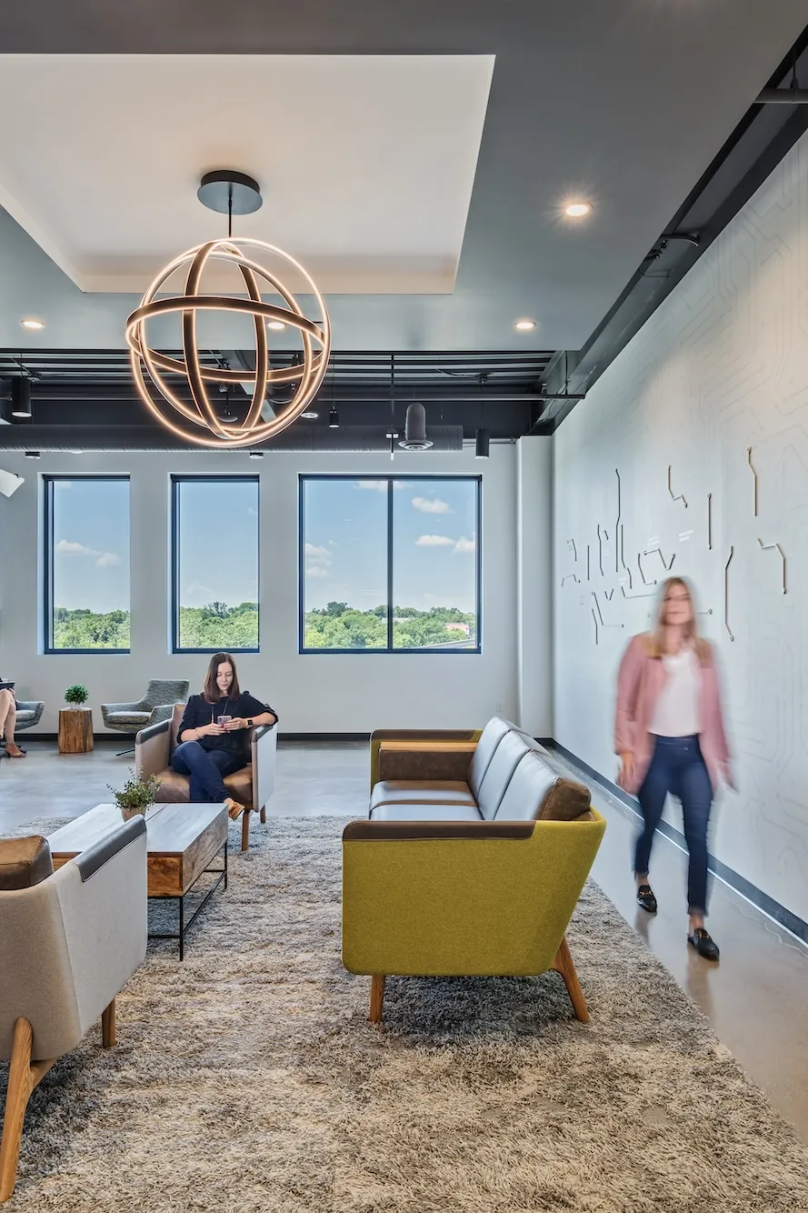 Interior of a lobby or lounge space with modern couches and a wall featuring a motherboard tech design