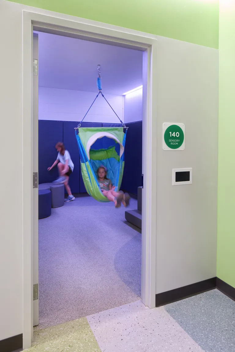 entrance to room with children playing and lit with purple lights