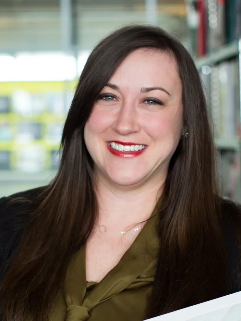 Riley Zollars smiling, wearing a black blazer and dark green blouse