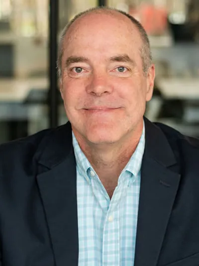 Tom Chidlow, smiling while wearing a navy blazer and blue shirt