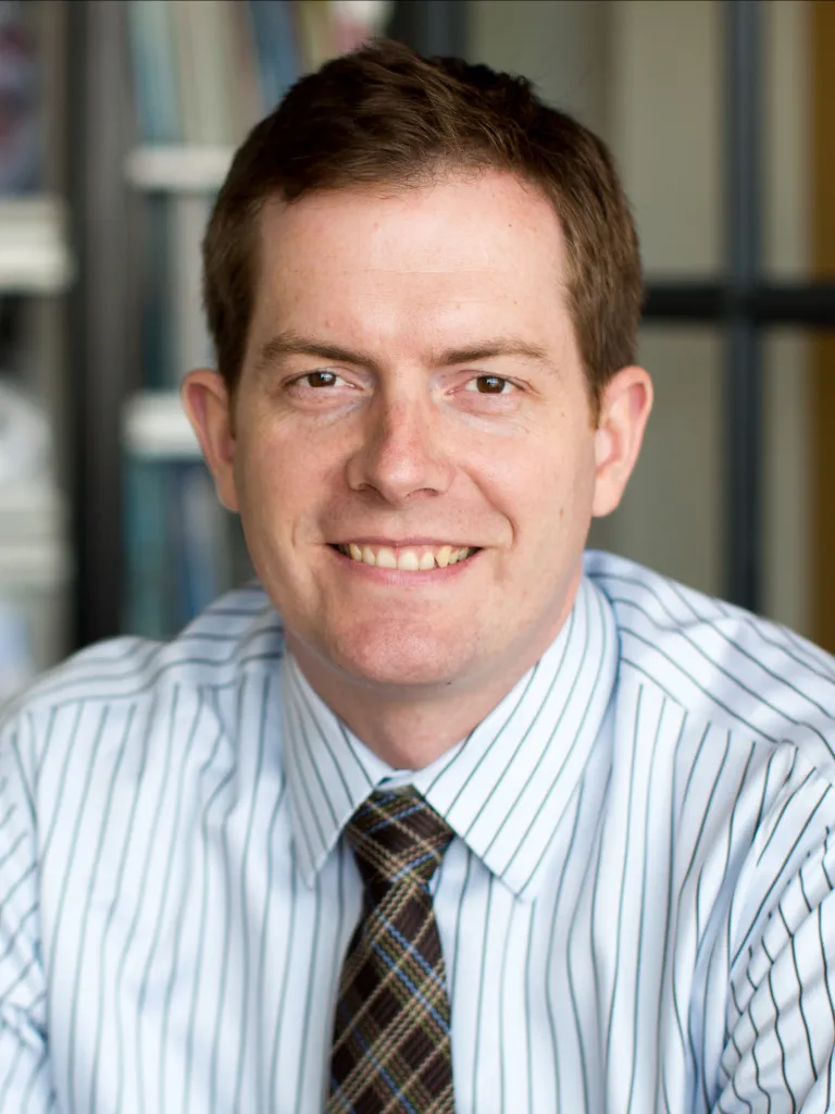 man in striped blue shirt and plaid tie