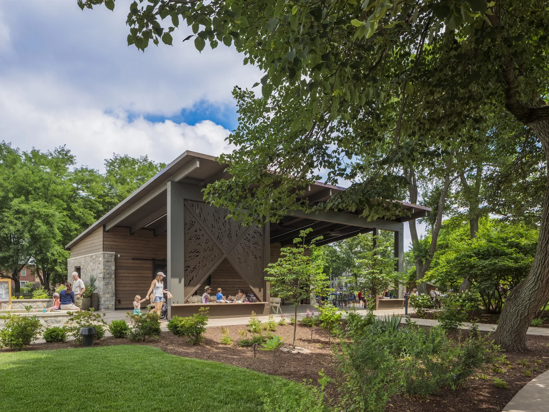 Outside daytime of a large gazebo surrounded by variety of plants and trees