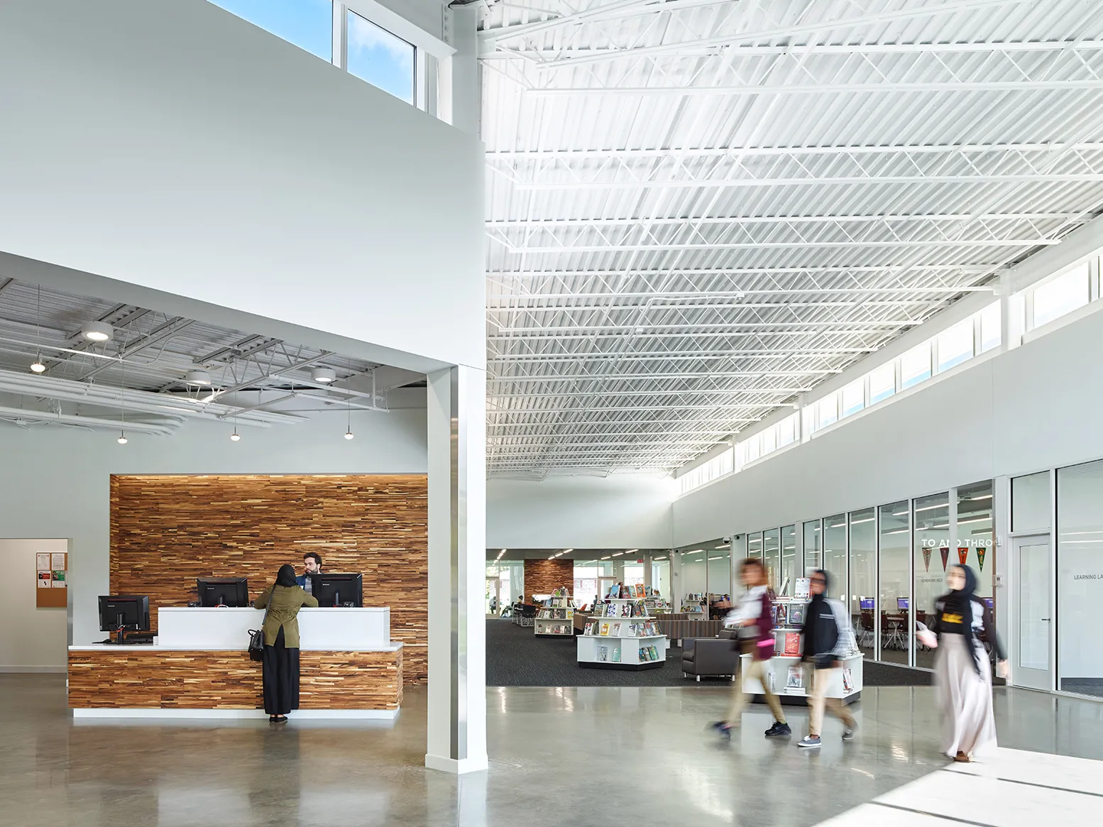 Interior view of the welcome desk in a brightly and naturally lit library.