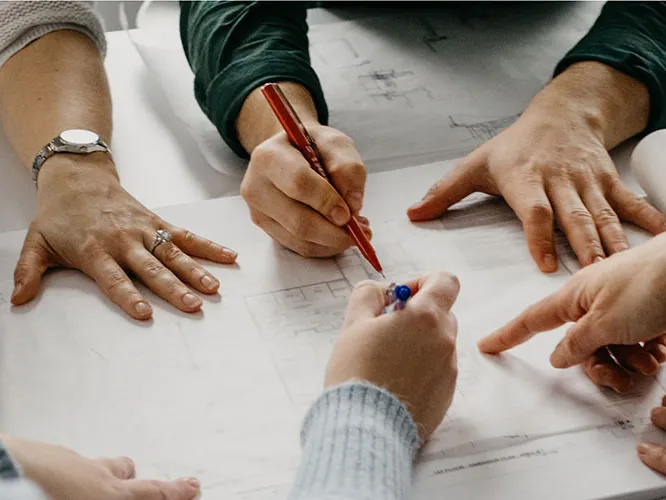 hands writing on plan