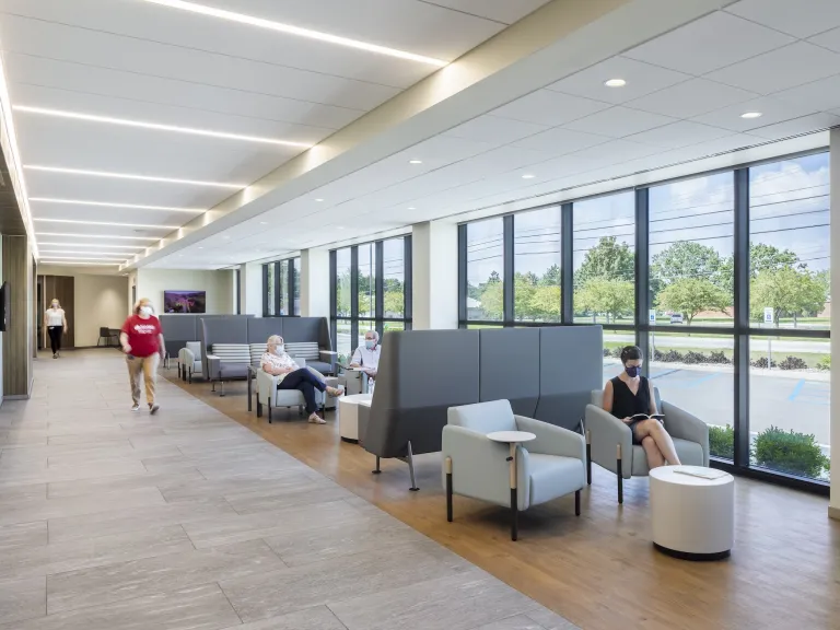 Lobby space within Wyandot hospital featuring floor to ceiling windows and variety of grey cushioned chairs