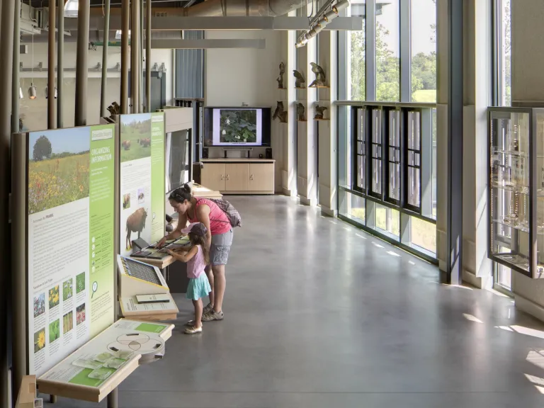 Interior of the Battelle Darby Creek Nature Center featuring children and adults interacting with the exhibits