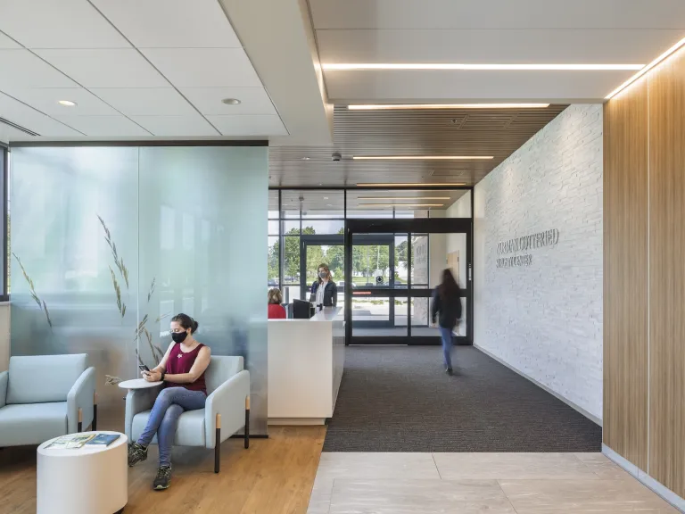 Brightly lit lobby entrance with someone sitting in a chair.