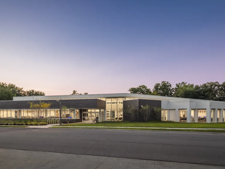 Exterior dusk of the Northern Lights Columbus Library, a modern grey and white floor to ceiling windowed building