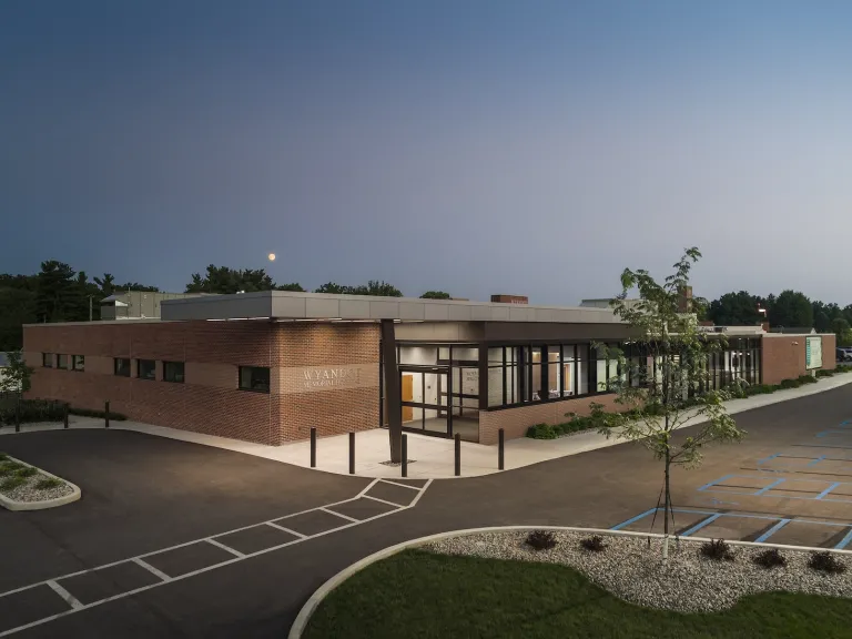 Exterior of Wyandot Hospital in evening, featuring one story brick building with floor to ceiling windows