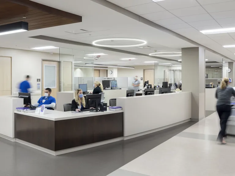 Norton Emergency Room front desk featuring dark wood accents and circular ceiling lights