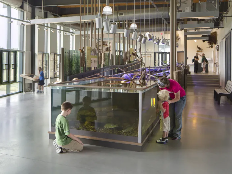Family looking at an aquatic tank at the Battelle Darby Creek Nature Center.